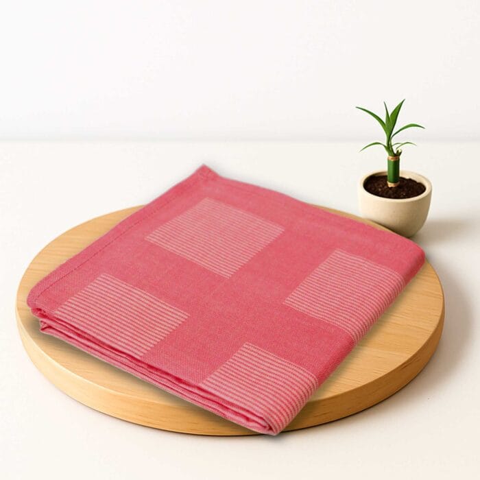 ZAHYA bamboo bath towel placed on wooden plate with small plant beside it