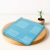 ZAHYA bamboo bath towel placed on wooden plate with small plant beside it