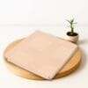 ZAHYA bamboo bath towel placed on wooden plate with small plant beside it
