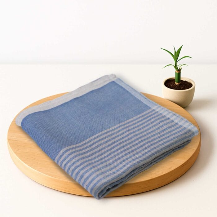 ZAHYA bamboo bath towel placed on wooden plate with small plant beside it