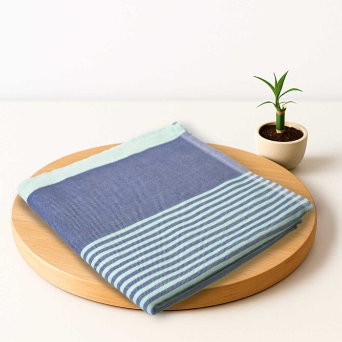 ZAHYA bamboo bath towel placed on wooden plate with small plant beside it