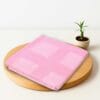 ZAHYA bamboo bath towel placed on wooden plate with small plant beside it