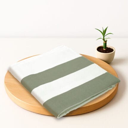 ZAHYA bamboo bath towel placed on wooden plate with small plant beside it
