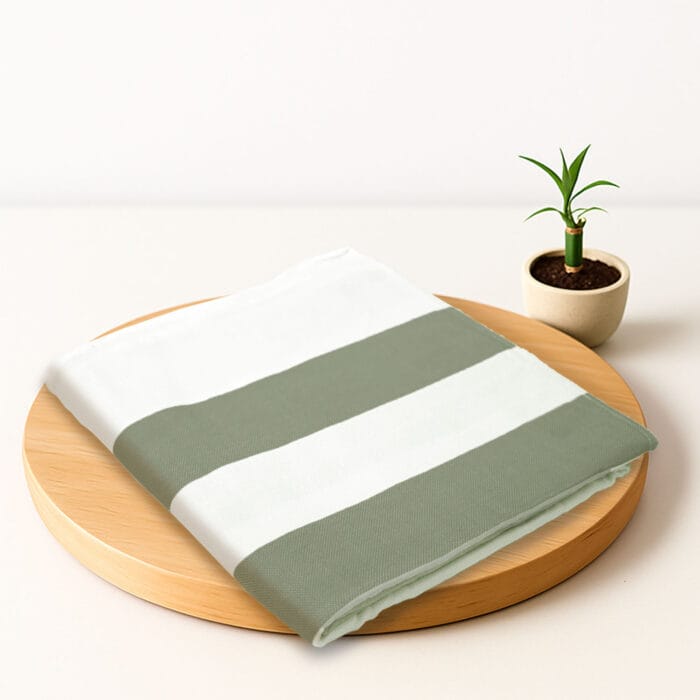 ZAHYA bamboo bath towel placed on wooden plate with small plant beside it