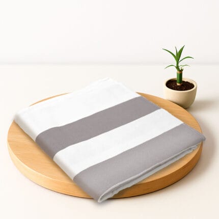 ZAHYA bamboo bath towel placed on wooden plate with small plant beside it