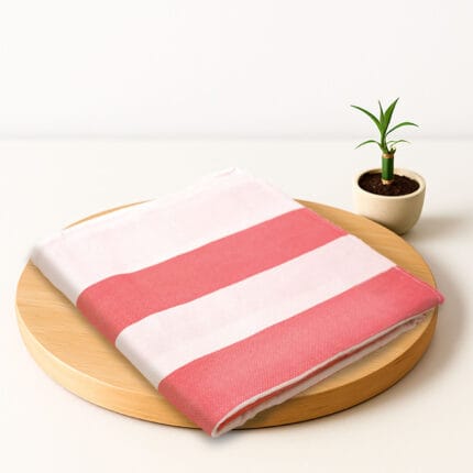 ZAHYA bamboo bath towel placed on wooden plate with small plant beside it