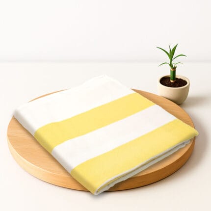 ZAHYA bamboo bath towel placed on wooden plate with small plant beside it