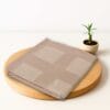 ZAHYA bamboo bath towel placed on wooden plate with small plant beside it