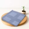 ZAHYA bamboo bath towel placed on wooden plate with small plant beside it