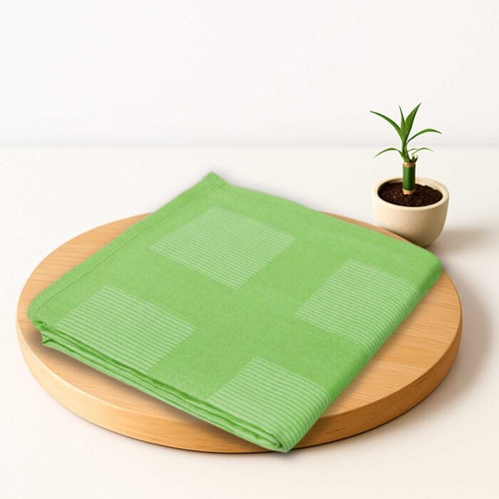ZAHYA bamboo bath towel placed on wooden plate with small plant beside it