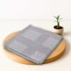 ZAHYA bamboo bath towel placed on wooden plate with small plant beside it