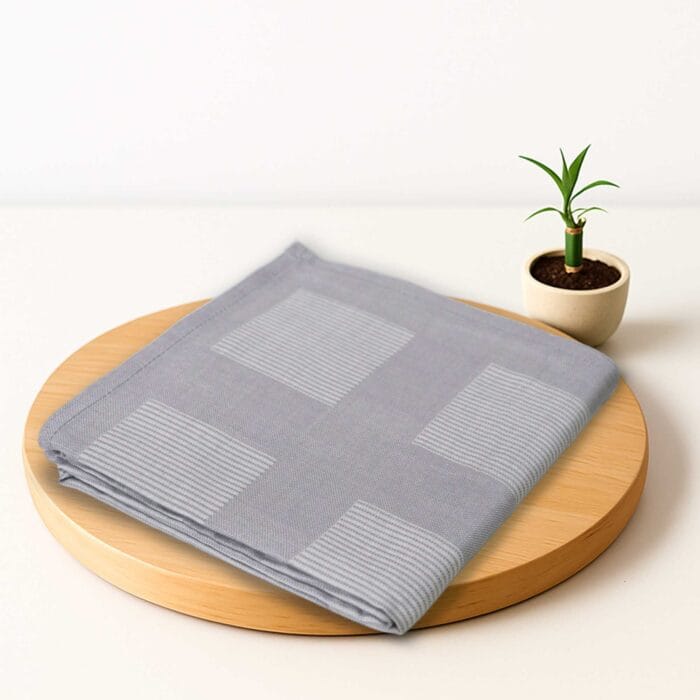 ZAHYA bamboo bath towel placed on wooden plate with small plant beside it