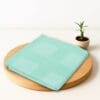 ZAHYA bamboo bath towel placed on wooden plate with small plant beside it