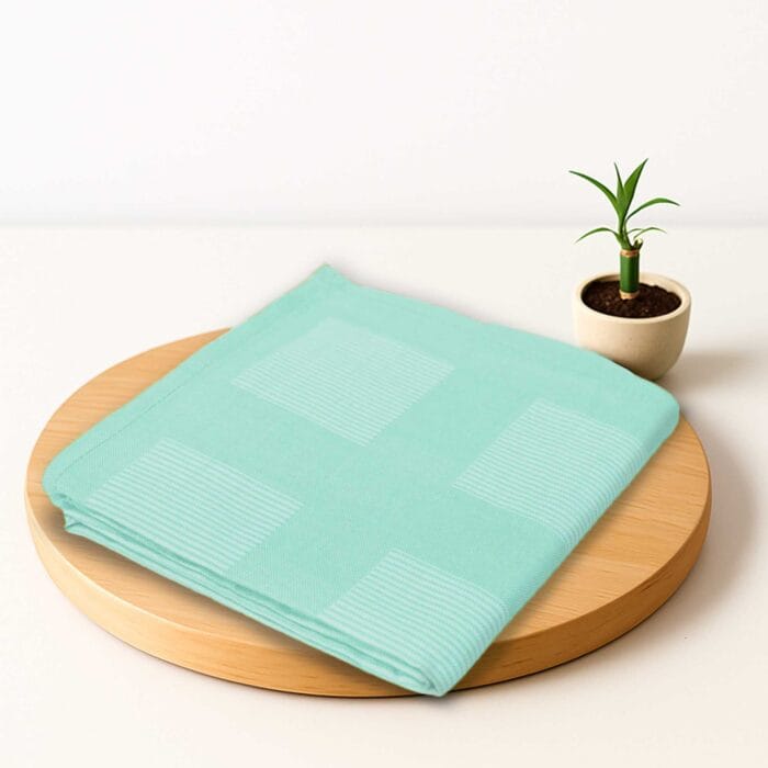 ZAHYA bamboo bath towel placed on wooden plate with small plant beside it
