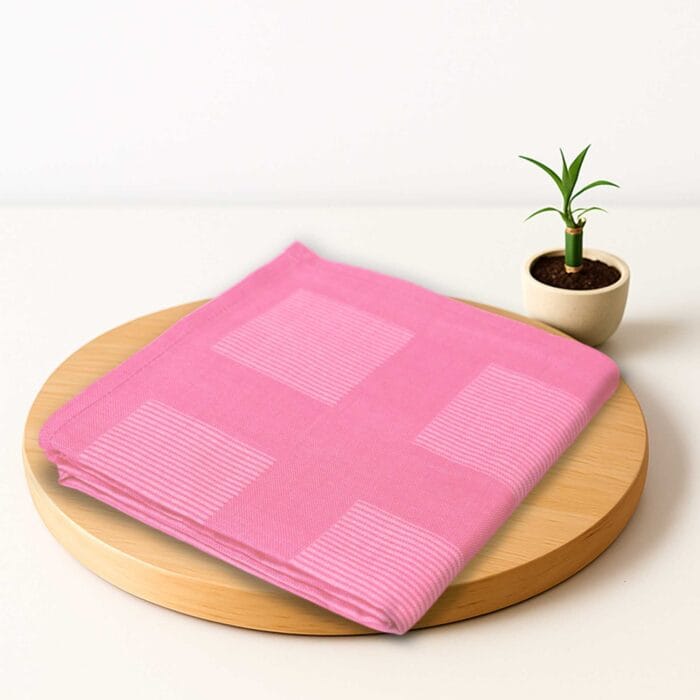ZAHYA bamboo bath towel placed on wooden plate with small plant beside it