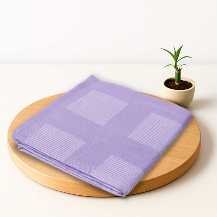 ZAHYA bamboo bath towel placed on wooden plate with small plant beside it