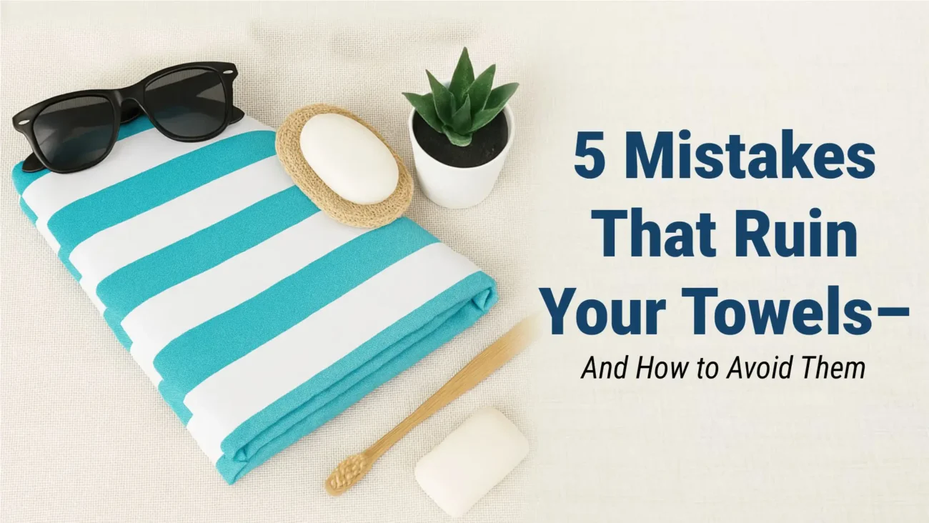 A neatly stacked set of soft cotton towels with one looking worn and frayed, symbolizing common mistakes that damage towels.