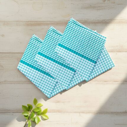 Three green check 22x22 cotton handkerchiefs neatly folded on a soft, neutral lifestyle background.