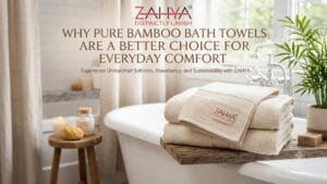 Folded ZAHYA bamboo bath towels stacked on a wooden bath tray beside a soaking tub
