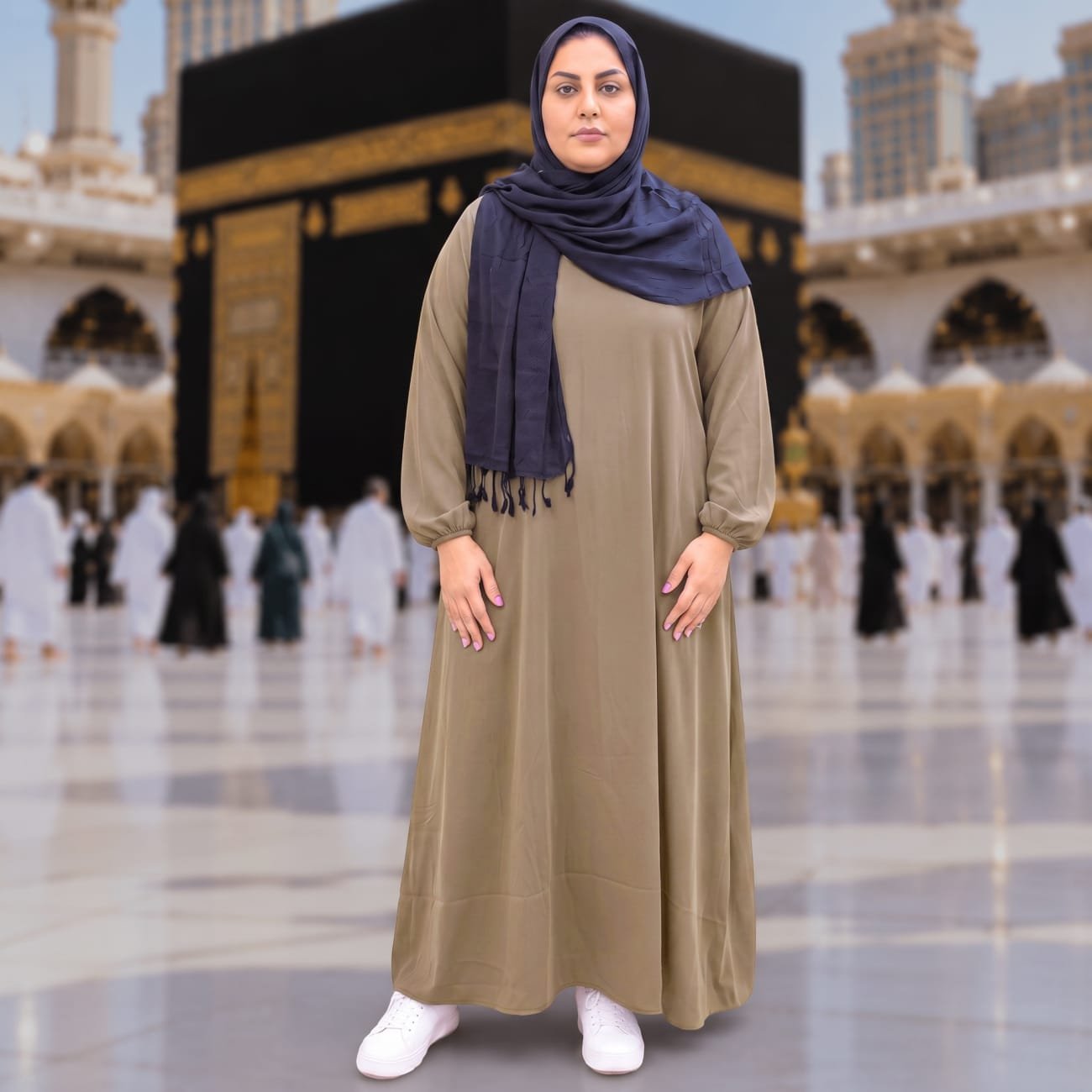 Woman wearing Zahya olive brown georgette Women's Ihram XXL with elastic cuffs and navy hijab, standing in front of the Kaaba, for Hajj and Umrah